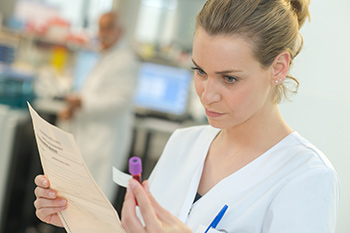 Phlebotomist looking at blood sample at one of our medical laboratories in Boise, Meridian, Nampa, Garden City, Idaho Falls, Pocatello or Rexburg.