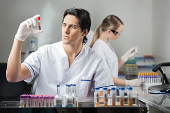 Laboratory tech looking at blood sample at one of our medical laboratories in Boise, Meridian, Nampa, Garden City, Idaho Falls, Pocatello or Rexburg.