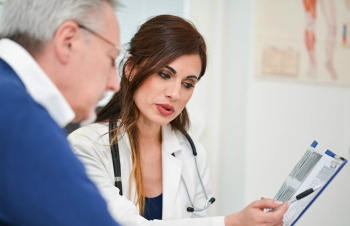 Health care provider showing lab results to elderly patient.