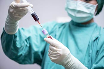 Lab worker with medical laboratory clinical blood sample, as part of the Employee Wellness program from Express Lab with locations in Boise, Garden City, Meridian, Idaho Falls, Pocatello and Rexburg.