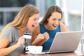 Two happy young adult women making payments online for wellness services including custom medical laboratory test panels available at Express Lab with locations in Boise, Garden City, Meridian, Idaho Falls, Pocatello and Rexburg.