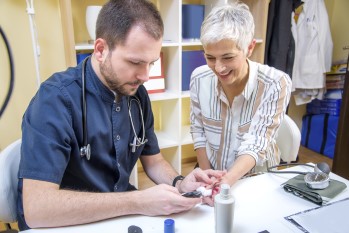 Health care provider drawing blood from elderly woman.