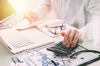 A person with a calculator doing finances. We support Boise, Garden City, Meridian, Idaho Falls, Pocatello and Rexburg.