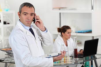 Physician on the phone talking with a medical lab worker with direct access at one of our Boise area - Garden City and Meridian, as well as Pocatello, Idaho Falls or Rexburg locations.